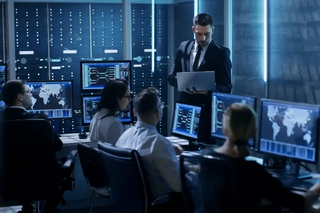 Manager reviewing laptop with cybersecurity team