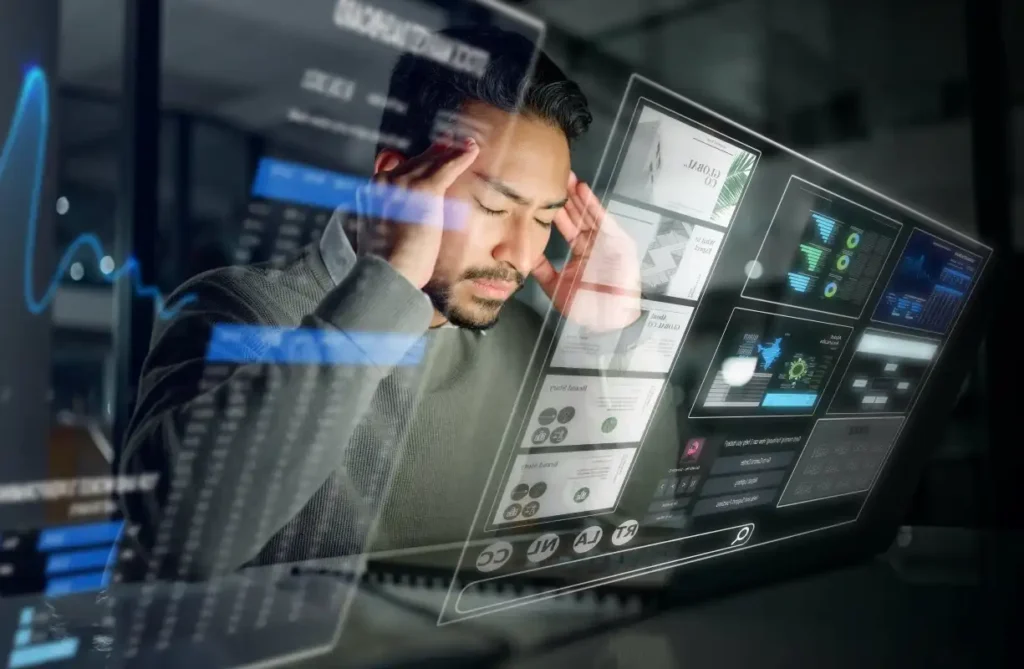 Man stressed while analyzing complex digital dashboard