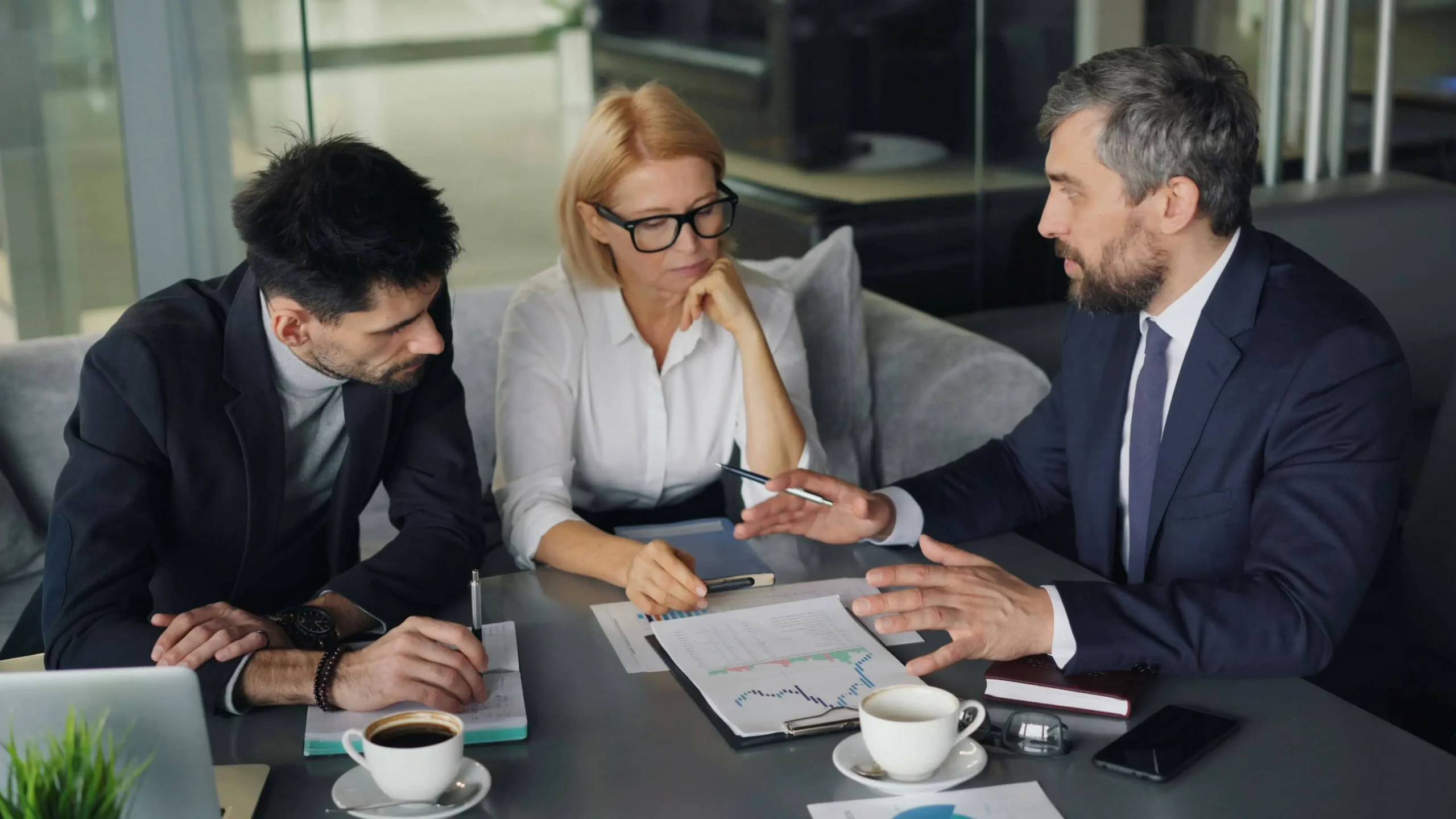 Advisor showing smartphone data to senior couple